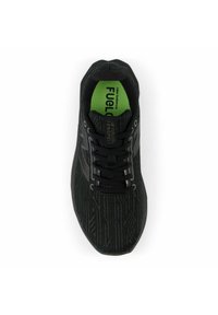 Black athletic shoe with textured upper, featuring a green insole, black laces, and a reflective logo accent. Hexagonal pattern on the surface.