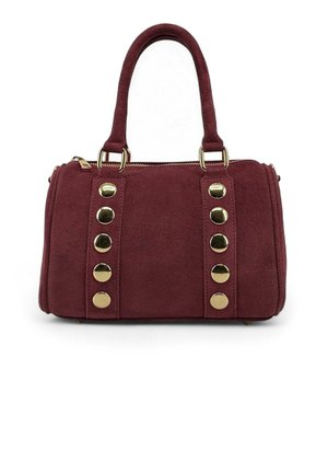 Sac à main en daim bordeaux avec deux anses courtes, des clous circulaires dorés sur le devant, et une fermeture éclair en haut.
