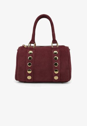 Sac à main en daim bordeaux avec deux anses courtes, des clous circulaires dorés sur le devant, et une fermeture éclair en haut.