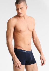 Marineblaue Boxerbriefs aus einem weichen, dehnbaren Material mit einem logobezogenen Bund. Das Design zeichnet sich durch eine eng anliegende Form und mittellange Beine aus.