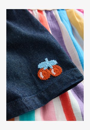 Materialul din denim prezintă un design colorat brodat cu o bicicletă în portocaliu și albastru. Fundalul afișează material dungat în diverse culori.