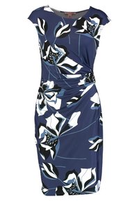 Robe bleue longueur genou avec de grands motifs floraux en noir, blanc et bleu clair, détaillée par un froncé à la taille.