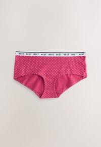 Culotte hipster rose à pois pour femme avec une ceinture élastique blanche affichant le texte "NEXT" répété en noir.