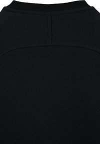 Tissu noir en gros plan montrant la partie haute du dos d'un vêtement avec un col côtelé et des détails de couture visibles.