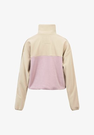 Veste en polaire avec un col haut, section supérieure beige et panneau inférieur rose clair. Texture douce avec une coupe carrée et des manches longues.
