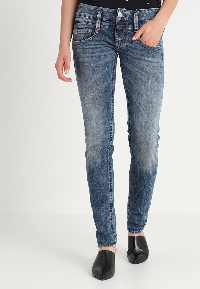 Smal denimjeans i en mellanblå tvätt med blekningar, femficksdesign och dragkedja. Bärs med svarta spetsiga ballerina.