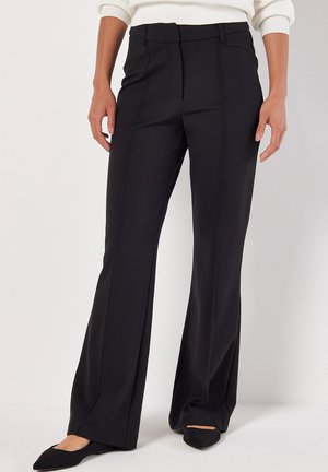 Pantalon noir ajusté avec une forme évasée, fabriqué à partir d'un matériau élégant. Présente des coutures avant et une taille mi-haute.