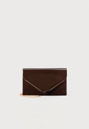 Pochette enveloppe brillante marron foncé avec une bandoulière chaîne dorée sur fond blanc.
