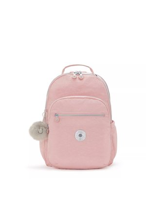 Pink backpack made of soft fabric with a round logo patch, silver zippers, front pocket, side pocket, and a fluffy pom-pom accessory.