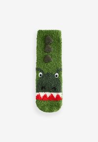 Calzino a tema dinosauro verde con pelliccia testurizzata, dotato di occhi bianchi, denti rossi e tre spine verde scuro sulla parte superiore, design giocoso.