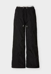 Μαύροι άνετοι παντελόνες νάιλον με ελαστική ζώνη μέσης και κορδόνι, τσέπες με φερμουάρ στο πλάι και ορατή εσωτερική ζώνη μέσης με την επωνυμία Tommy Jeans.