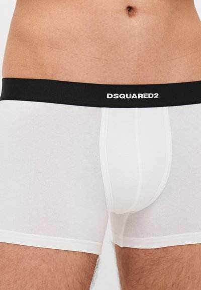 Boxeri pentru bărbați albi dintr-o țesătură fină, cu un brâu elastic negru pe care este înscris logo-ul "DSQUARED2" în alb.