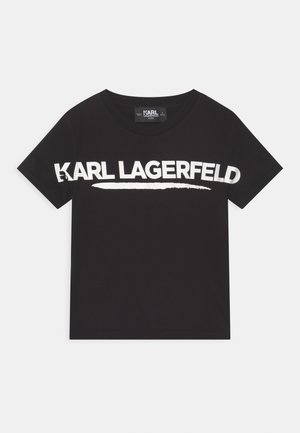 Camiseta negra de algodón con mangas cortas. En la parte frontal presenta un gran texto blanco "KARL LAGERFELD" y un gráfico de una pincelada blanca. Cuello redondo.