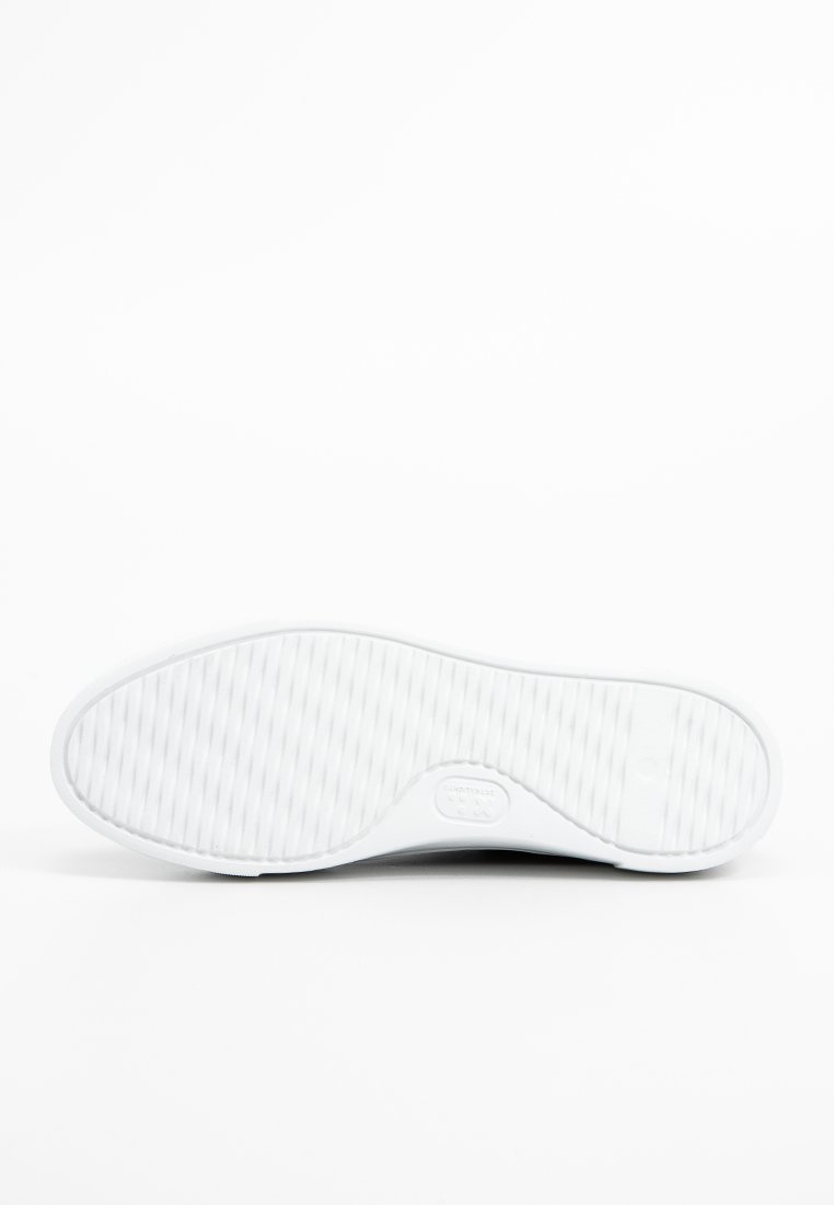 Weiße Sneaker-Sohle mit strukturierter Oberfläche, die horizontale und vertikale Rillen für besseren Halt aufweist. Minimalistisches Design ohne sichtbare Markenkennzeichnung.