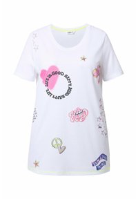 T-shirt en coton blanc avec un col rond, des manches courtes, des graphismes imprimés colorés comprenant des étoiles, des cœurs et des accents textuels.