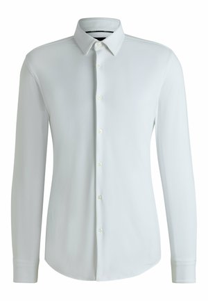 Camicia bianca a maniche lunghe con bottoni, realizzata in tessuto testurizzato, con colletto a punta e orlo dritto. Presenta bottoni standard sulla parte anteriore.