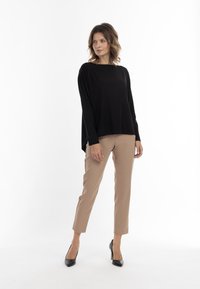 Mustat pitkähihaiset paita, rento malli, kevyt kangas, yhdistetty vaaleanruskeisiin slim-fit-housuihin ja mustiin korkokenkiin, minimalistinen muotoilu.
