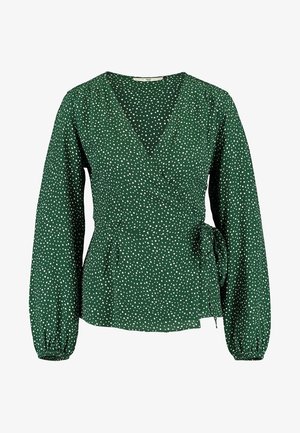 Blouse cache-coeur verte à manches longues avec pois blancs, col en V, poignets froncés et lien sur le côté à la taille.