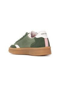 Zapatilla verde con parte superior de ante y sintético, acentos blancos, suela de goma y una franja rosa en el talón. Textura suave, diseño bajo.