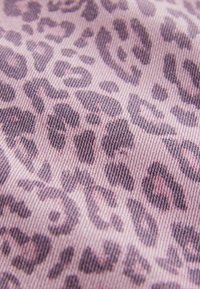 Textília s leopardím vzorom v svetloružovej farbe, s tmavohnedými škvrnami, s jemnou textúrou a diagonálnym tkaným vzorom. Mäkká, odolná tkanina.