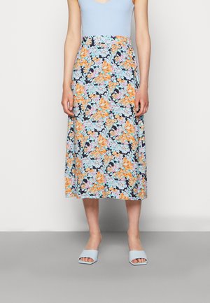 Saia midi floral com flores laranja e azul claro sobre um fundo azul marinho, combinada com uma blusa azul clara e sandálias azuis de slide.