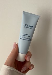 Tubetto squeezer blu chiaro con base bianca. Il testo riporta "LUMENE [HERKKÄ] NORDIC SENSITIVE WEIGHTLESS MOISTURIZER" in caratteri blu scuro.