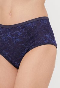 Lace hipster briefs in dark purple with floral pattern, featuring a smooth waistband and textured fabric for added detail.