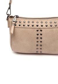 Borsa a tracolla in pelle sintetica beige con finitura testurizzata, caratterizzata da dettagli in rivetti neri lungo la cerniera e il corpo per decorazione.