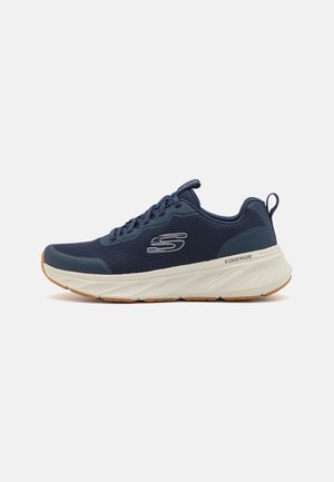 Baskets de sport bleu marine avec semelle épaisse blanche, lacets à l'avant, logo "S" sur le côté et étiquette "EDGERIDE" près du talon sur fond clair.