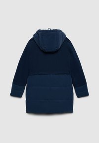 Giacca imbottita blu navy con cappuccio, caratterizzata da un motivo trapuntato nella parte inferiore e tessuto liscio nella parte superiore. Maniche lunghe, vestibilità morbida.