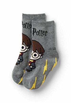 Graue Baumwollsocken mit einer Cartoonfigur, die braune Haare, eine Brille und einen Schal trägt. Akzente sind gelbe Blitze und der Text "Potter".