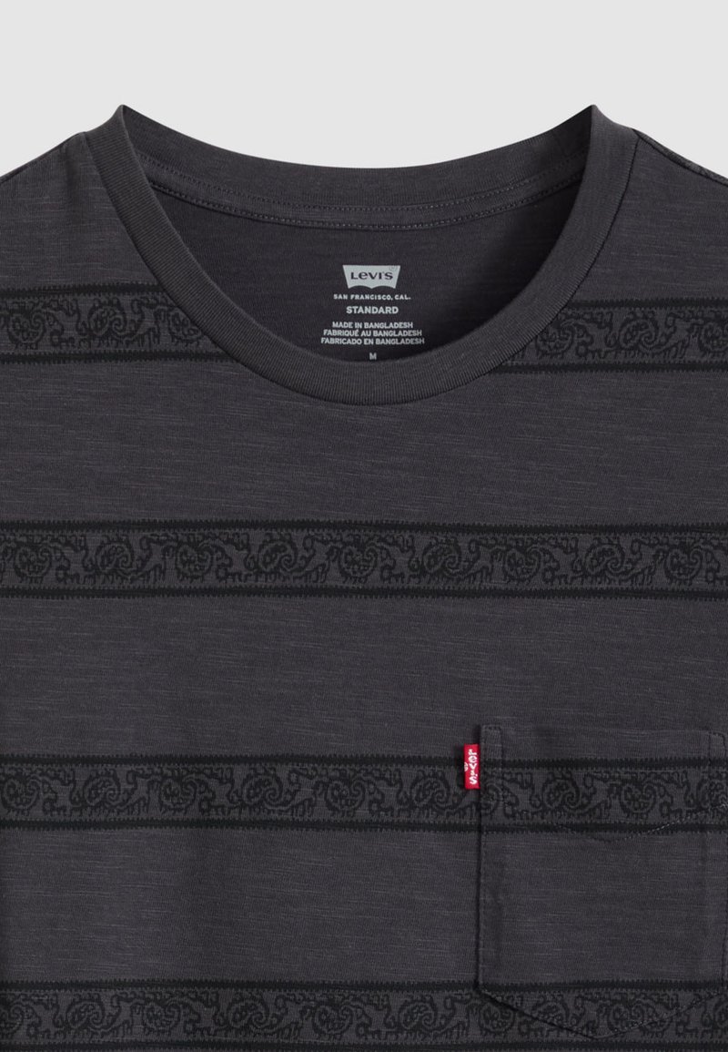 T-shirt Levi's gris foncé avec des rayures horizontales noires en motif et une poche poitrine avant avec une petite étiquette rouge Levi's.