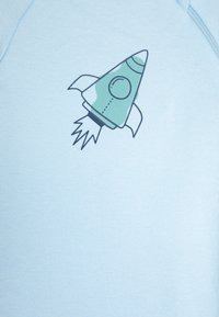 Svetlo modra dukserica z grafiko zelene rakete s črnimi obrobami in belimi plameni. Mehka tekstura in sproščen dizajn.