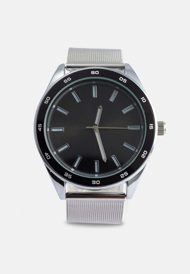 Orologio rotondo con quadrante nero, indici delle ore argentati e cinturino in maglia argentata. Presenta una cassa argentata e una lunetta nera con marcature dei minuti.