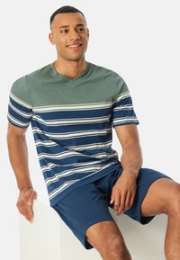 Gestreiftes Kurzarm-T-Shirt in Grün und Marineblau mit V-Ausschnitt. Kombiniert mit marineblauen Shorts. Glattes Baumwollmaterial, lässige Passform.