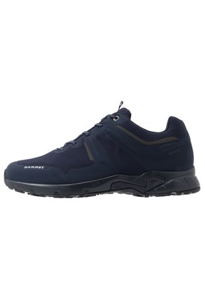 Black low-cut hiking shoe with rugged sole, lace-up front, and Mammut logo on the toe area, designed for outdoor use.