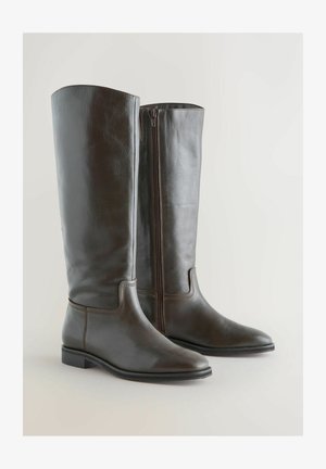 Brune læder knæhøje støvler med et strømlinet design, spidse tæer og en lynlås på siden. Flad hæl og diskrete syninger fremhæver stilen.