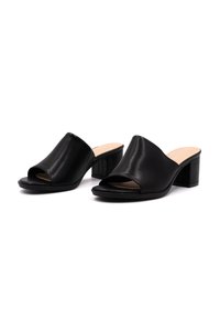 Mule aperti in pelle nera con tomaia curva, tacco a blocco e texture liscia. Caratterizzati da un design minimalista e una soletta neutra.