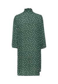 Blouse verte à pois blancs, tissu léger, manches courtes, coupe ample, col haut et fente au dos pour faciliter les mouvements.
