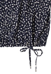 Tissu bleu marine avec motif abstrait blanc, doté d'un ourlet froncé avec un cordon de serrage et des accents métalliques argentés. Matière douce et texturée.