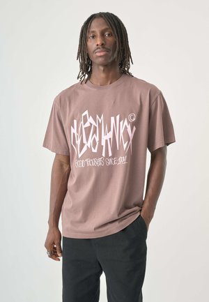 Brown cotton t-shirt with oversized fit featuring white graphic text design "Good Thoughts Since April," short sleeves, and crew neckline.