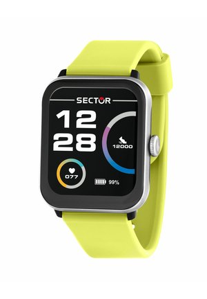 Smartwatch con cinturino giallo, che mostra l'ora 12:28, frequenza cardiaca 77, obiettivo passi 12.000 e batteria al 99% su un display digitale.