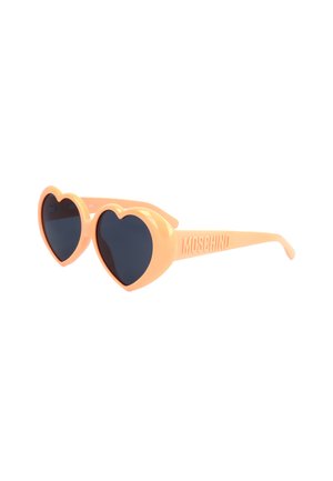 Occhiali da sole a forma di cuore con montatura color pesca e lenti scure, con il nome del marchio Moschino sull'asta.