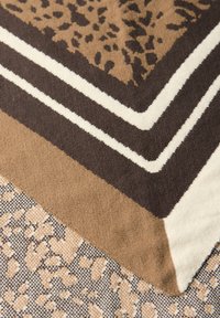 Tissu brun à motifs géométriques ; présente des rayures contrastées en crème et brun foncé, une texture douce et une texture visuelle beige clair.