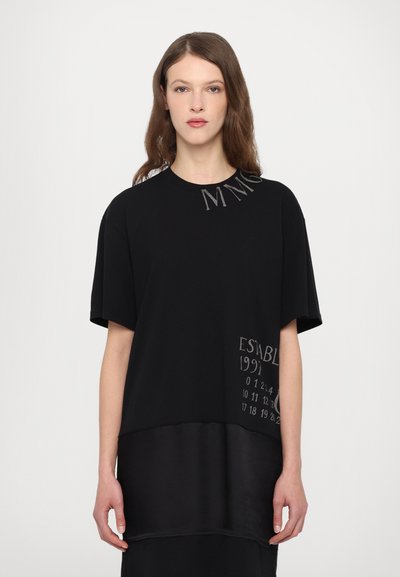 T-shirt noir à manches courtes avec un texte contrastant "MINE" et "ÉTABLI 1991", doté d'un ourlet inférieur en satin pour une texture supplémentaire.