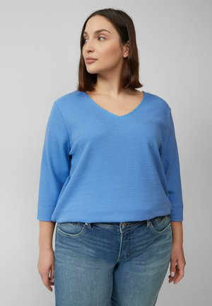 Lichtblauwe, gestructureerde V-halstrui met driekwartmouwen, gecombineerd met blauwe spijkerbroek; casual, relaxte pasvorm.