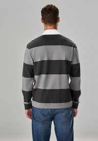 Long-sleeve shirt in gray and black horizontal stripes, featuring a white collar and ribbed cuffs, made from smooth fabric.