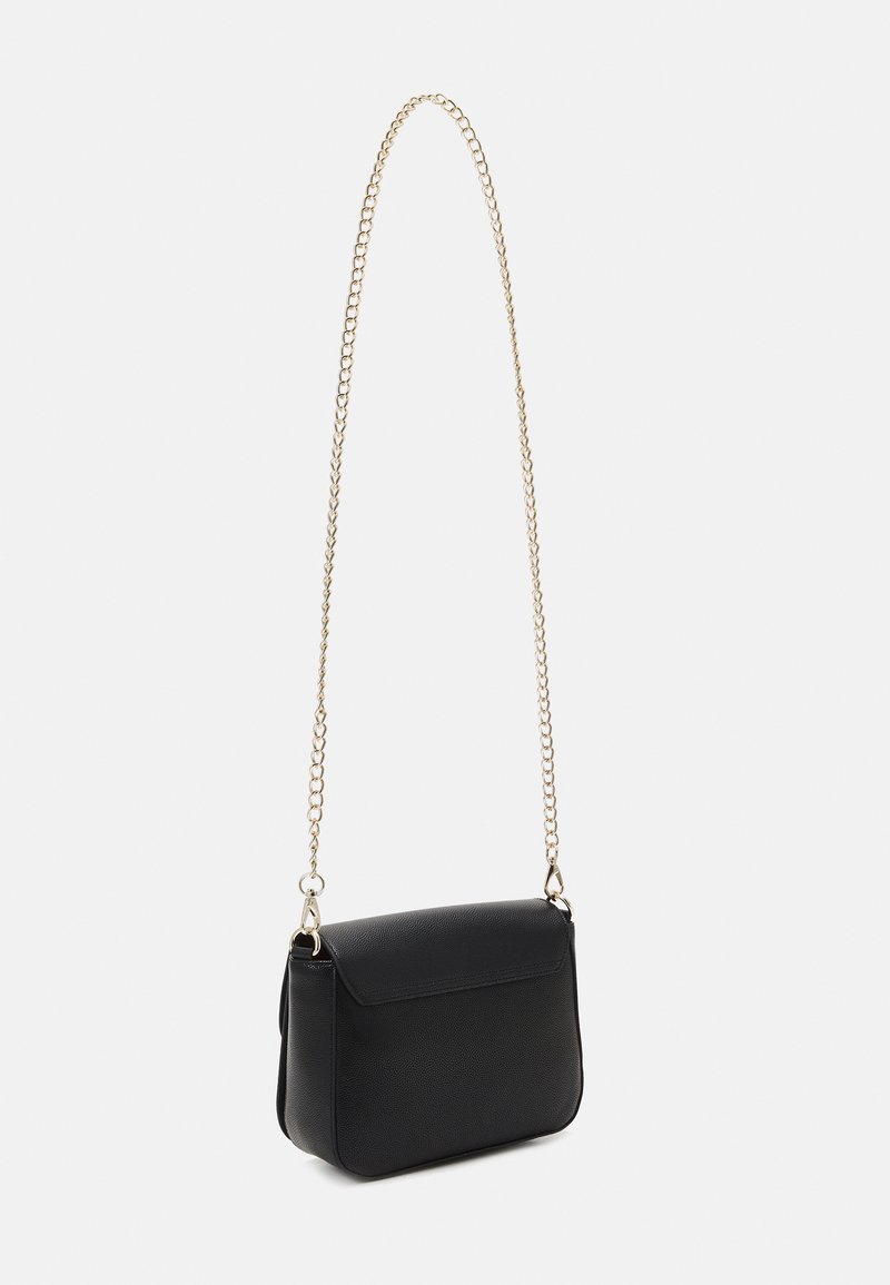 Bolso de mano de imitación cuero negro, texturizado, con forma rectangular, tapa con solapa y una correa de cadena dorada para llevar.