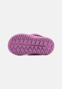 Semelle de chaussure en caoutchouc violet avec un motif texturé comportant des rainures en zigzag et de petites speckles pour une meilleure adhérence.
