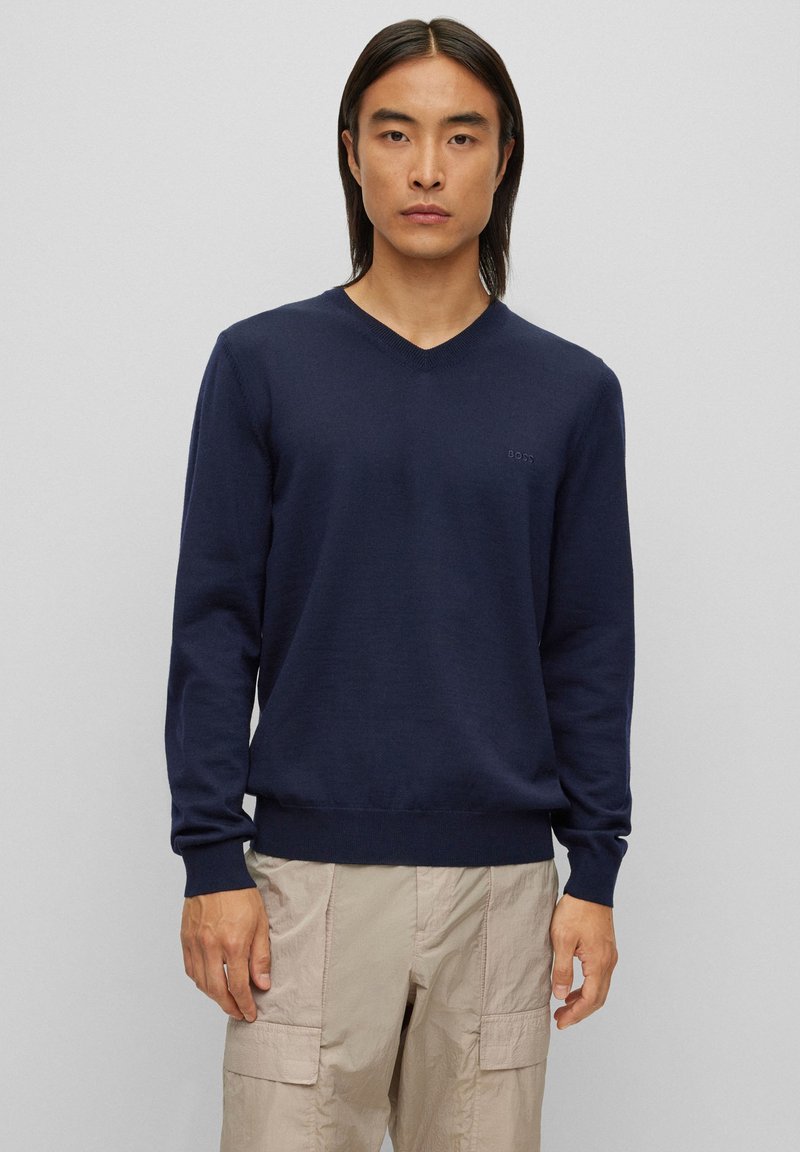 Ναυτικό μπλε πουλόβερ V-neck σε μαλακό πλεκτό ύφασμα, με μακριά μανίκια και εφαρμοστό στρίφωμα. Διακριτική λεπτομέρεια λογότυπου στην αριστερή πλευρά του στήθους.